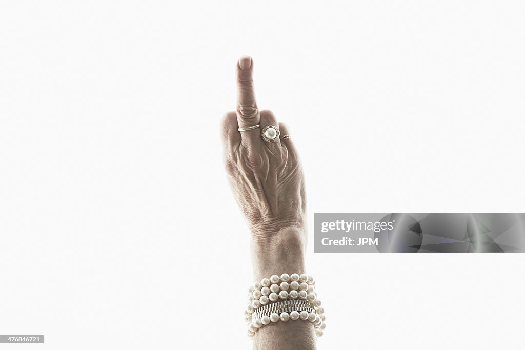 Studio shot of mature woman's hand making obscene gesture