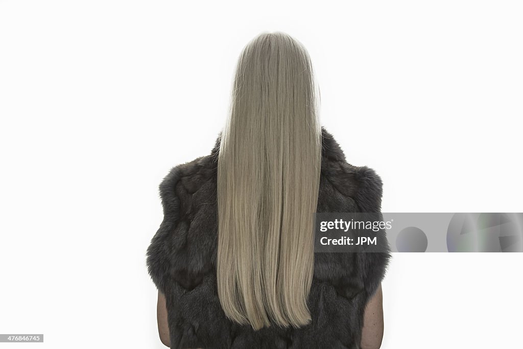 Rear view studio shot of mature woman with long grey hair