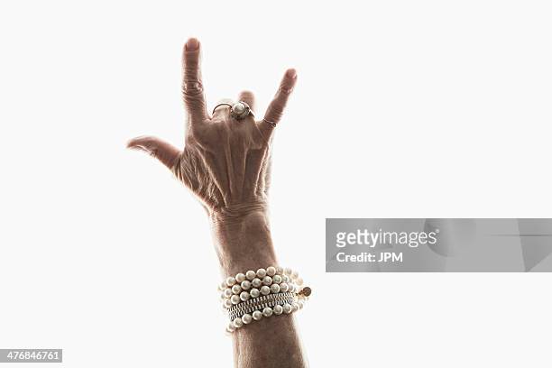 studio shot of mature woman's hand making gesture - geste de la main photos et images de collection