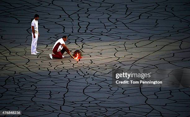 Final torchbearer Ilham Zakiyev carries the flame into the stadium during the Opening Ceremony for the Baku 2015 European Games at the Olympic...