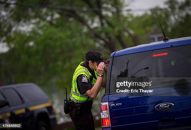 State trooper looks into the back of a vehicle at a roadblock on June 12, 2015 in Cadyville, New York. Law enforcement continued their search for...