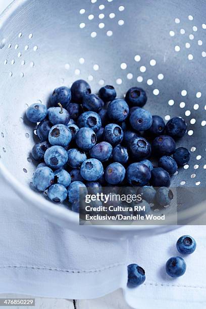 blueberries in a colander on a white tablecloth - égouttoir photos et images de collection