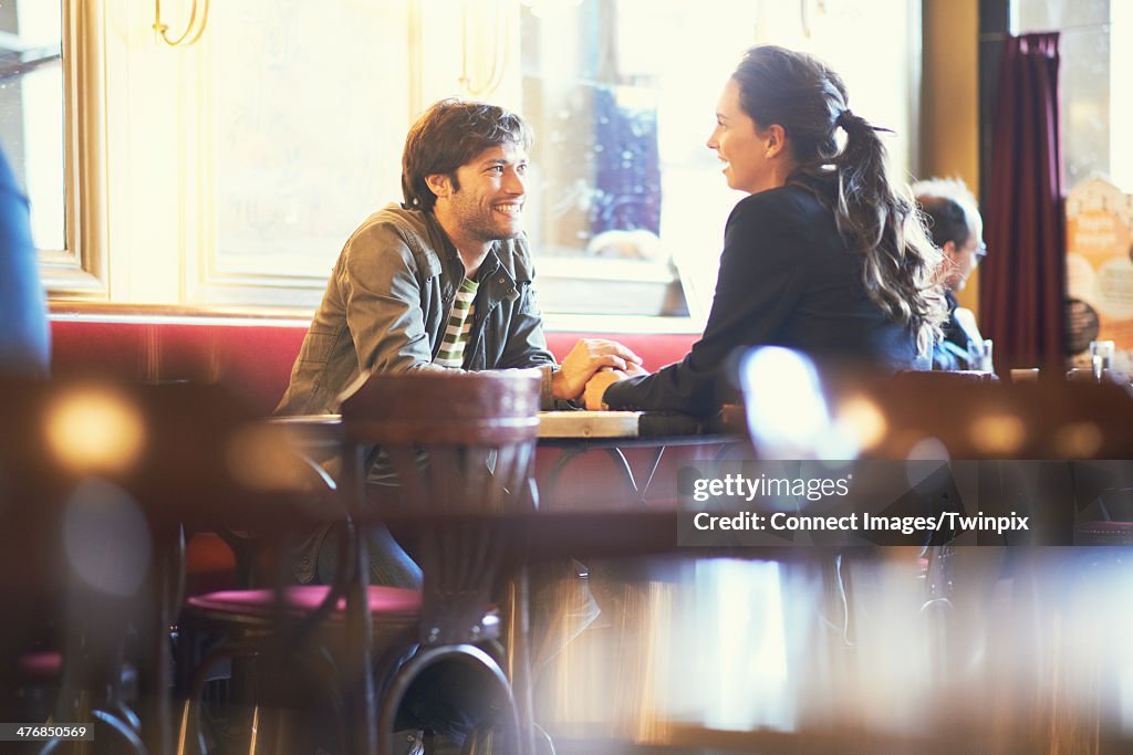 Couple holding hands in cafe bar