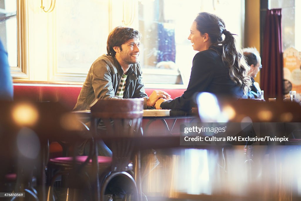 Couple holding hands in cafe bar