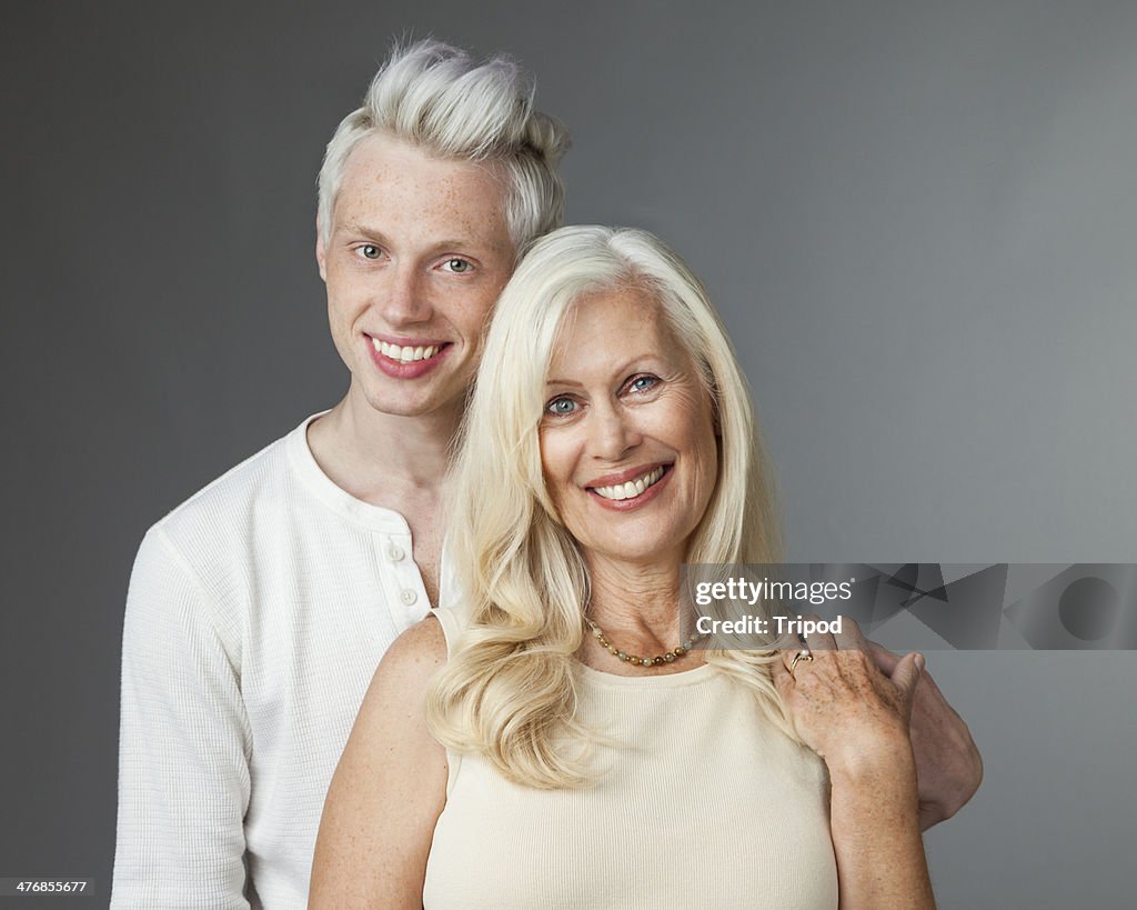 Adult son standing behind mature mother portrait