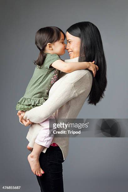 woman holding daughter touching noses (2-4) - nuzzling stockfoto's en -beelden