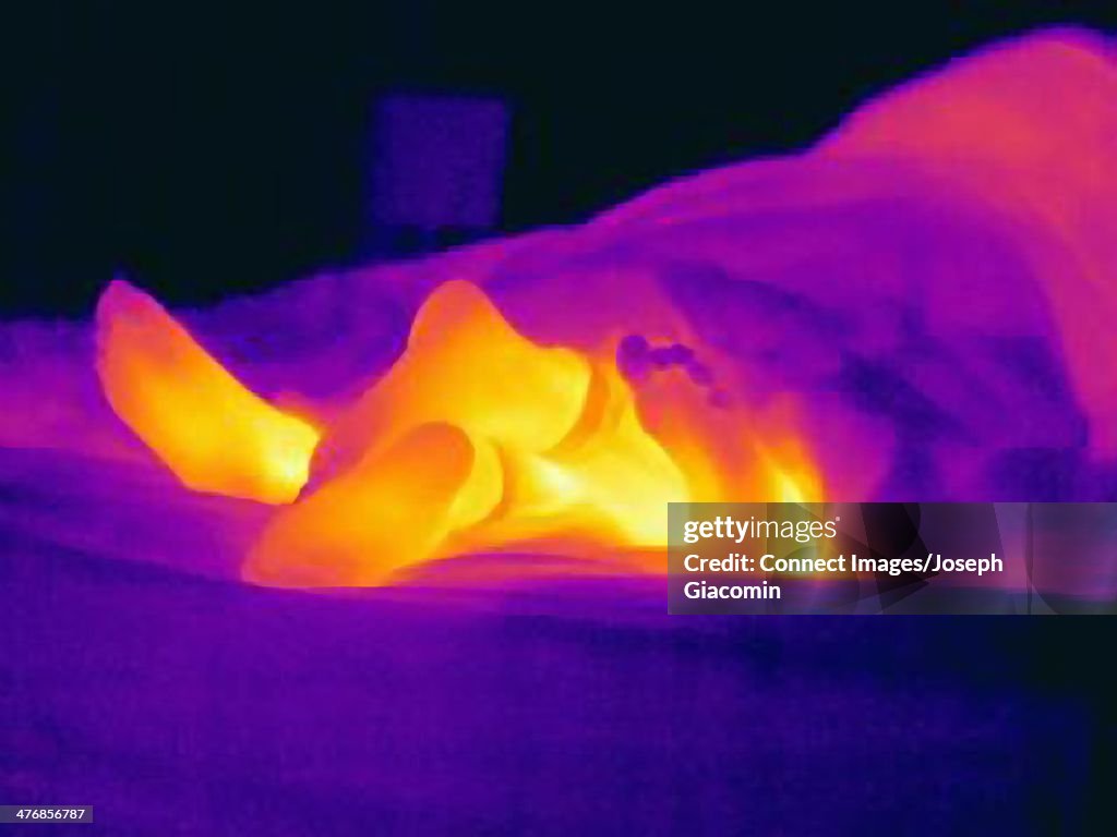 Thermal image of young couple in bed