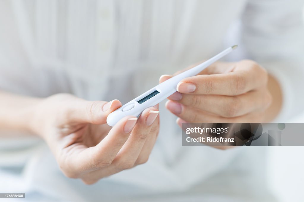 Woman looking at thermometer