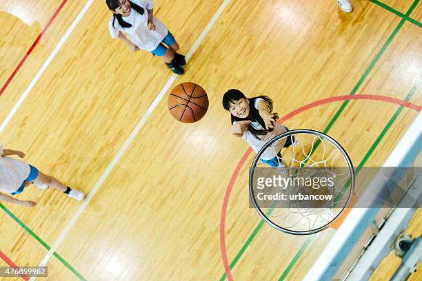 japanese high school. a school gymnasium. children play basketball - taking a shot sport stock pictures, royalty-free photos & images
