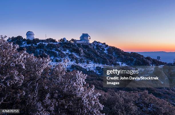 the sun sets at kitt peak, arizona, as the wiyn observatory prepares to go to work. to the left is the .9 meter telescope observatory. - kitt peak observatorium stockfoto's en -beelden