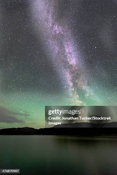 aurora borealis and milky way above fish lake, whitehorse, yukon, canada. - infinite tucker stock pictures, royalty-free photos & images