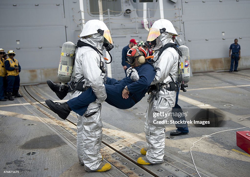 April 22, 2013 - Sailors simulate rescuing a pilot during a crash and salvage drill aboard the guided-missile destroyer USS William P. Lawrence (DDG-110).