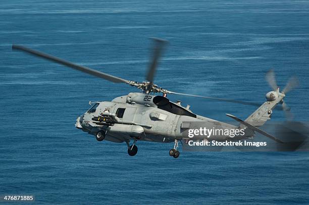 south china sea, may 18, 2013 - an mh-60r sea hawk helicopter maneuvers over the south china sea. - south china sea stock pictures, royalty-free photos & images