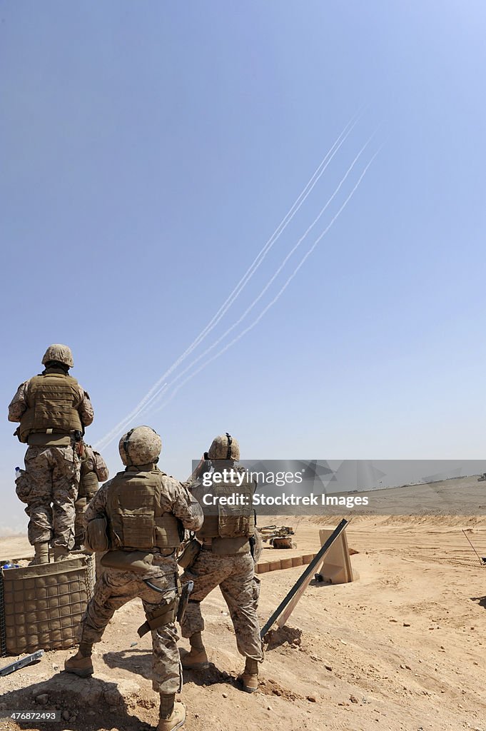 Seabees watch rockets fire overhead.