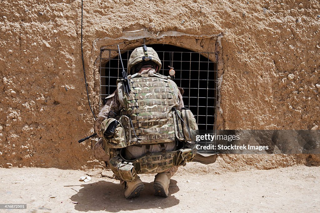 July 18, 2013 - Soldier searches a compound during Operation Grizzly in Helmand province, Afghanistan.