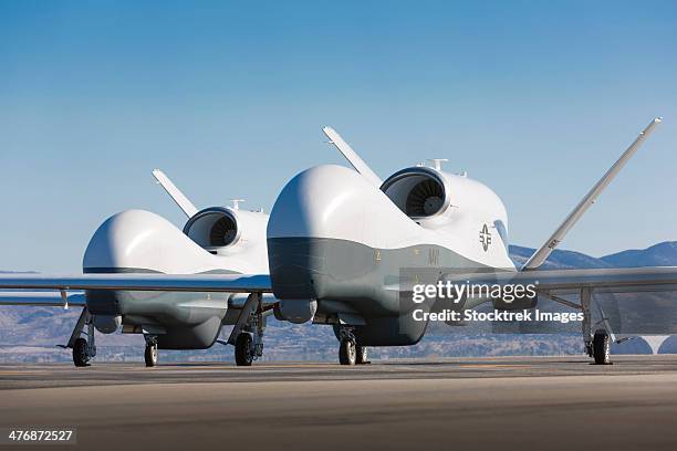 two mq-4c triton unmanned aerial vehicles on the tarmac. - palmdale stock pictures, royalty-free photos & images