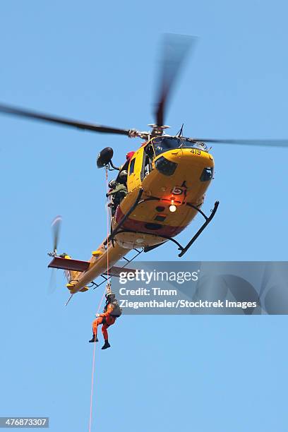 ch-146 griffon helicopter of the canadian air force during winching operations in kiel, germany. - abseilen stockfoto's en -beelden