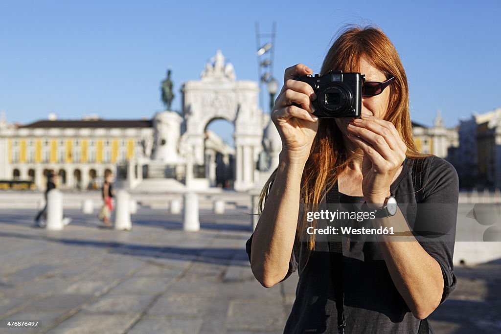 Portugal, Lisboa, Baixa, Praca do Comercio, woman photographing in front of triumphal arch