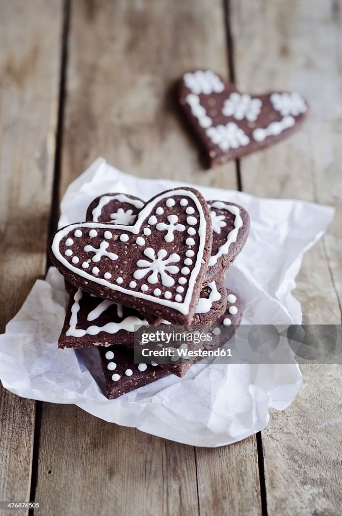 Stack of heart-shaped gingerbread decorated with sugar icing on paper