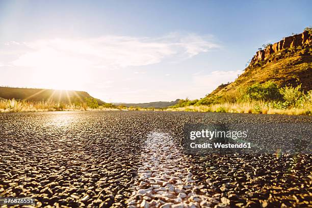 australia, western australia, sunlight and empty road - bodenmarkierung stock-fotos und bilder