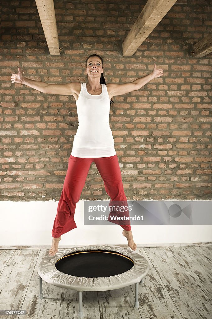 Germany, Bavaria, Woman jumping on trampoline