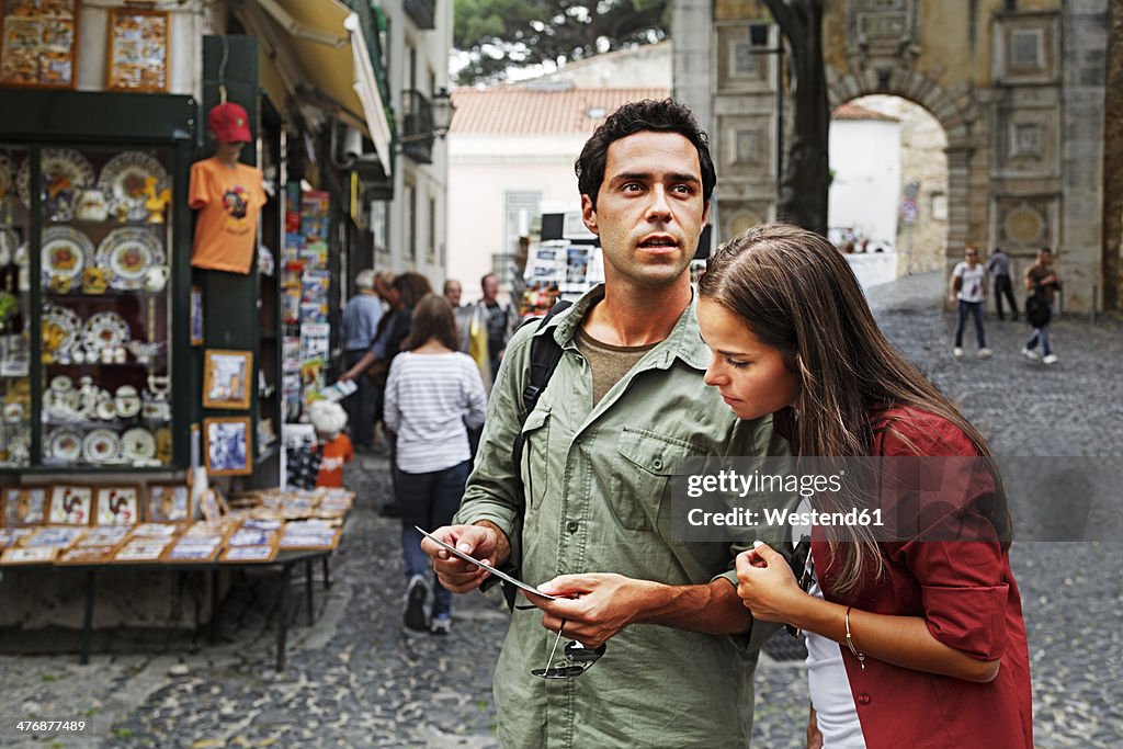 Portugal, Lisboa, Baixa, Rossio, young couple looking at postcard