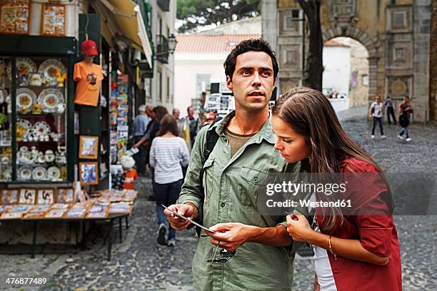 portugal, lisboa, baixa, rossio, young couple looking at postcard - lisbon people stock pictures, royalty-free photos & images