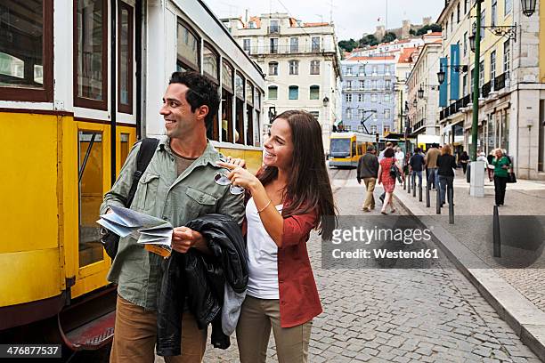 portugal, lisboa, baixa, rossio, young couple with city map in front of tram - lisbon people stock pictures, royalty-free photos & images