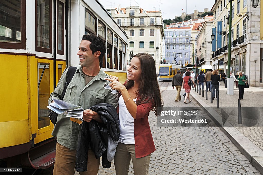 Portugal, Lisboa, Baixa, Rossio, young couple with city map in front of tram