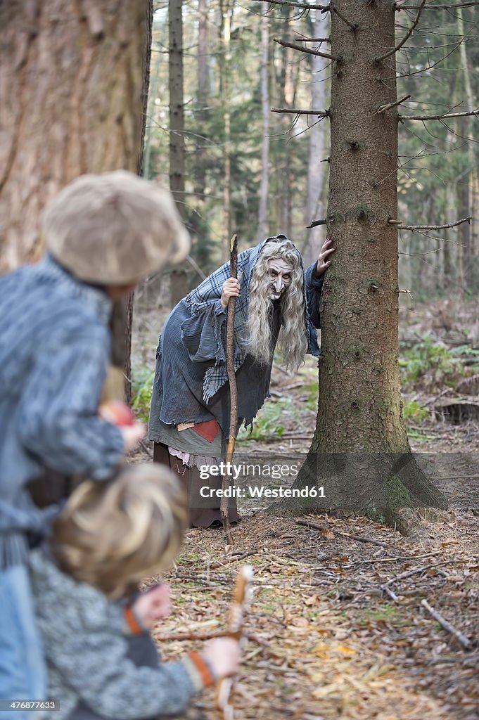 Germany, North Rhine-Westphalia, Moenchengladbach, Scene from fairy tale Hansel and Gretel, witch looking at children in the woods