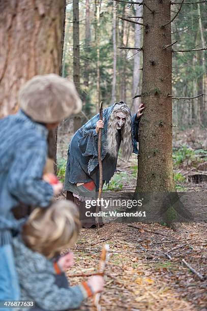 germany, north rhine-westphalia, moenchengladbach, scene from fairy tale hansel and gretel, witch looking at children in the woods - hänsel and gretel stock pictures, royalty-free photos & images