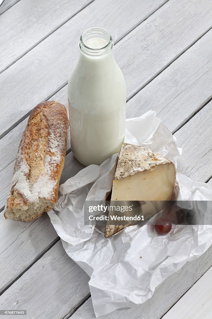 Sheep cheese, milk and bread on wooden table
