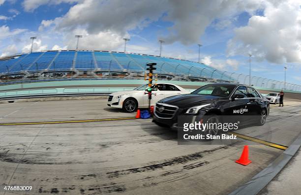 Participates race to the finish line during the Cadillac V-Series Challenge driving experience at the Homestead-Miami Speedway for the World Golf...