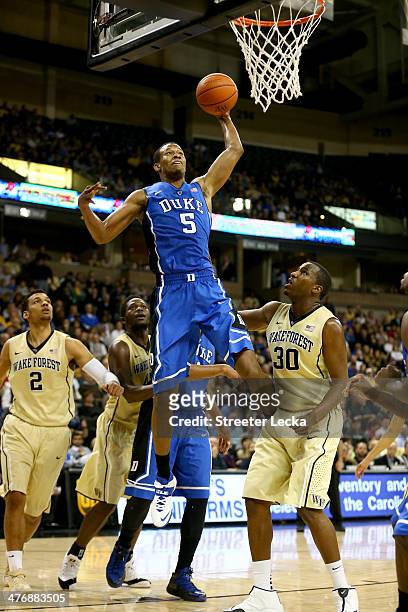 Rodney Hood of the Duke Blue Devils drives to the basket against Travis McKie of the Wake Forest Demon Deacons during their game at Joel Coliseum on...