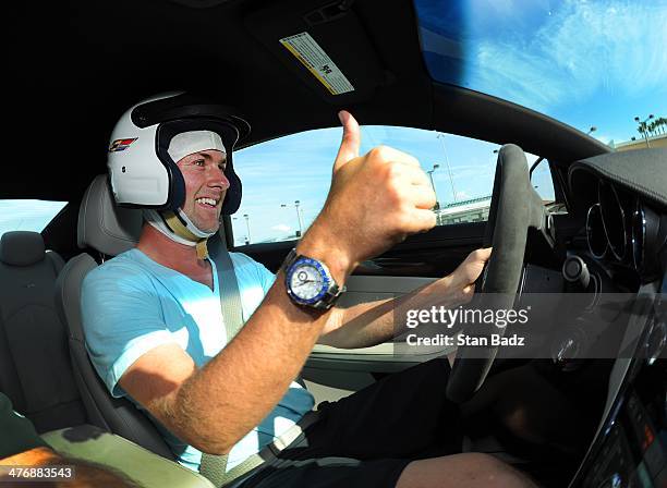 Webb Simpson races his car around the track during the Cadillac V-Series Challenge driving experience at the Homestead-Miami Speedway for the World...