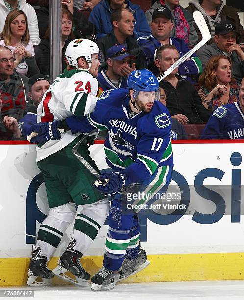 Ryan Kesler of the Vancouver Canucks checks Matt Cooke of the Minnesota Wild during their NHL game at Rogers Arena February 28, 2014 in Vancouver,...