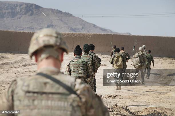 Soldiers with the U.S. Army's 4th squadron 2nd Cavalry Regiment and the Afghan National Army patrol into a village on March 5, 2014 near Kandahar,...