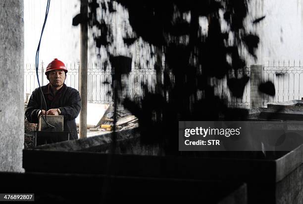 China-environment-energy-politics-Congress,FOCUS by Carol HUANG This picture taken on March 5, 2014 shows a laborer working at a coal mining facility...