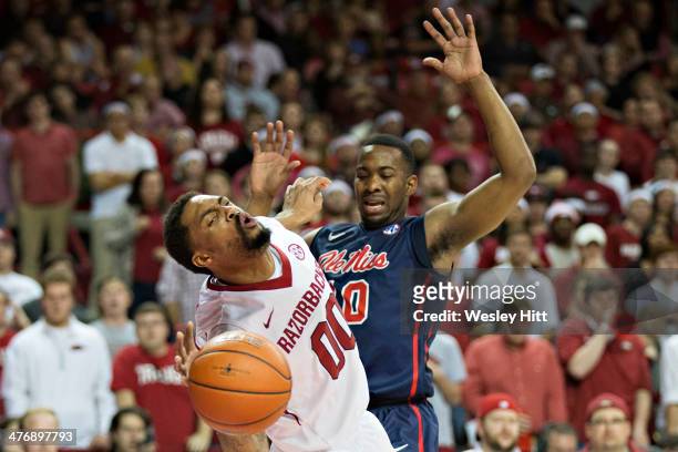 Rashad Madden of the Arkansas Razorbacks is fouled by LaDarius White of the Ole Miss Rebels at Bud Walton Arena on March 5, 2014 in Fayetteville,...