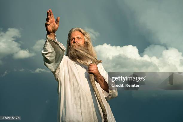 long-haired prophet gesturing in front of dramatic sky - senior man grey long hair stock pictures, royalty-free photos & images