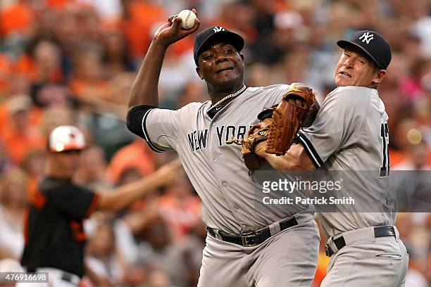 Starting pitcher Michael Pineda of the New York Yankees collides with teammate third baseman Chase Headley as he tries to throw out Jimmy Paredes of...