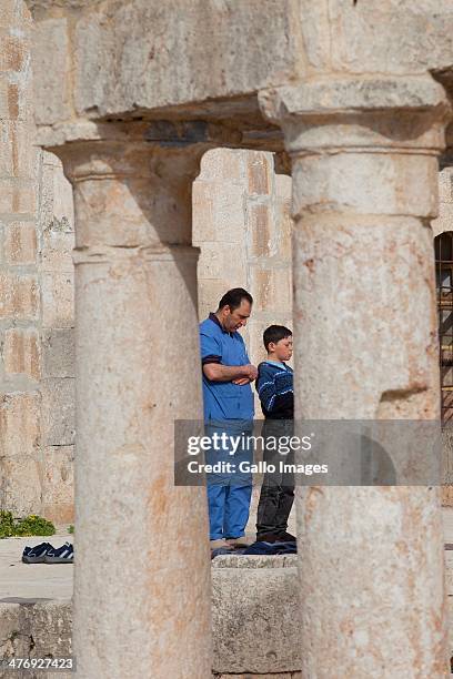 Men pray at the Umayad Mosque on February 27 in Atmeh, Syria. The ancient mosque minaret was damaged in the bombings. More than 20 000 people have...