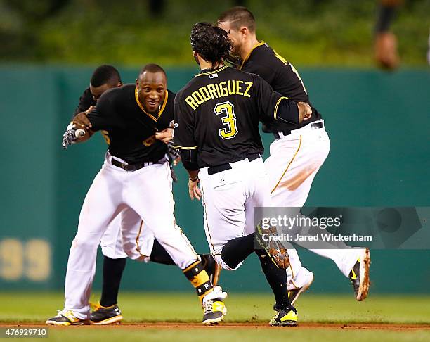 Starling Marte of the Pittsburgh Pirates is mobbed by his teammates after hitting the game-winning RBI single in the 13th inning against the...