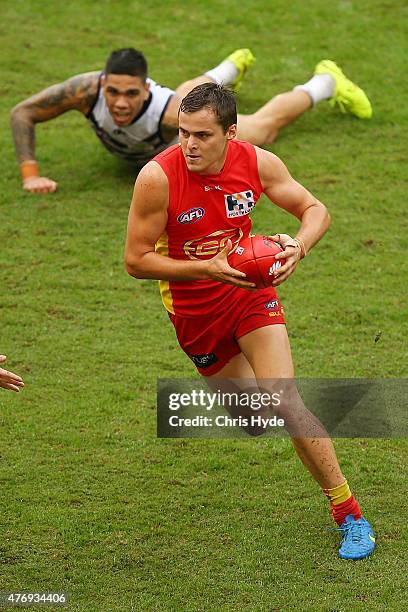 Kade Kolodjashnij of the Suns runs the ball during the round 11 AFL match between the Gold Coast Suns and the Fremantle Dockers at Metricon Stadium...