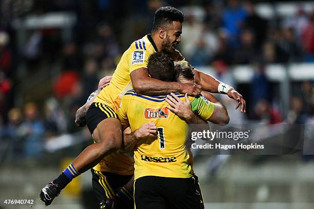 Rey Lee-Lo and Callum Gibbins of the Hurricanes congratulate Conrad Smith on his try during the round 18 Super Rugby match between the Chiefs and the...