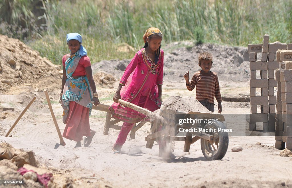 An Indian girl, Kavita (12 years old), works along with her...