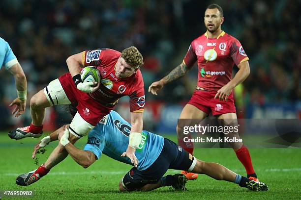 Adam Thomson of the Reds is tackled by Jacques Potgieter of the Waratahs during the round 18 Super Rugby match between the Waratahs and the Reds at...