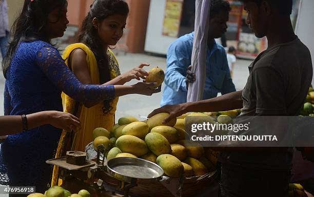 Indian visitors and prospective buyers inspect different varieties of mangoes displayed during the 4th Gitanjali Mango Festival in Siliguri on June...