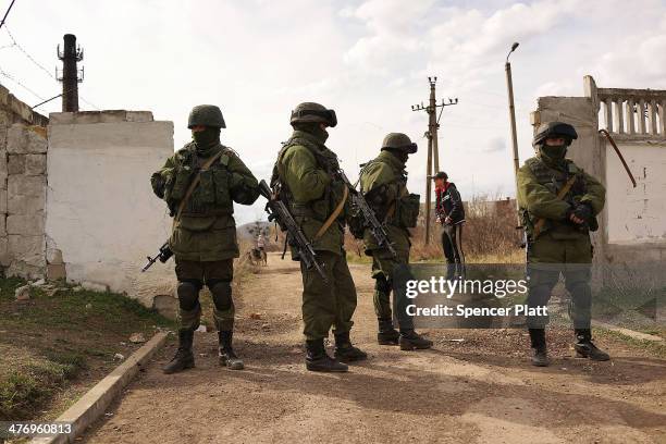 Russian paramilitaries stand guard outside of a Ukrainian military base in the town of Perevevalne near the Crimean city of Simferopol on March 6,...