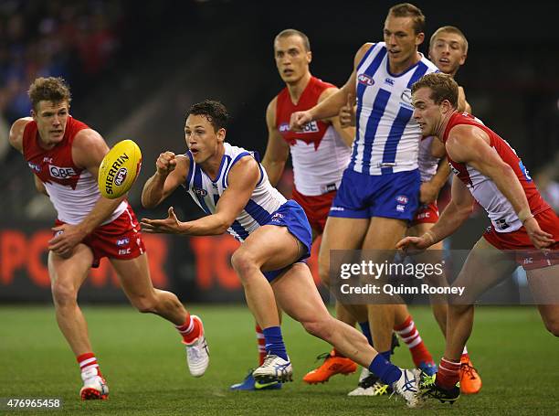 Ben Jacobs of the Kangaroos handballs during the round 11 AFL match between the North Melbourne Kangaroos and the Sydney Swans at Etihad Stadium on...